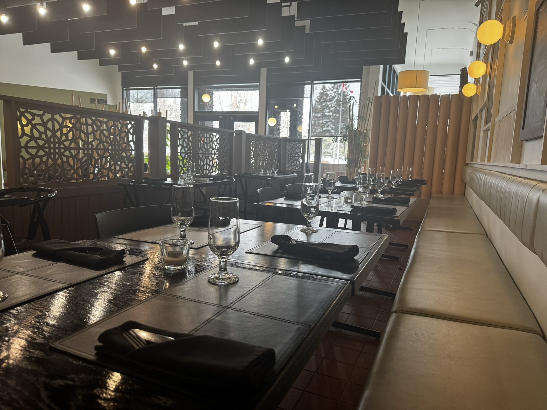 Les banquettes et les tables dressées, le long de la baie vitrée
