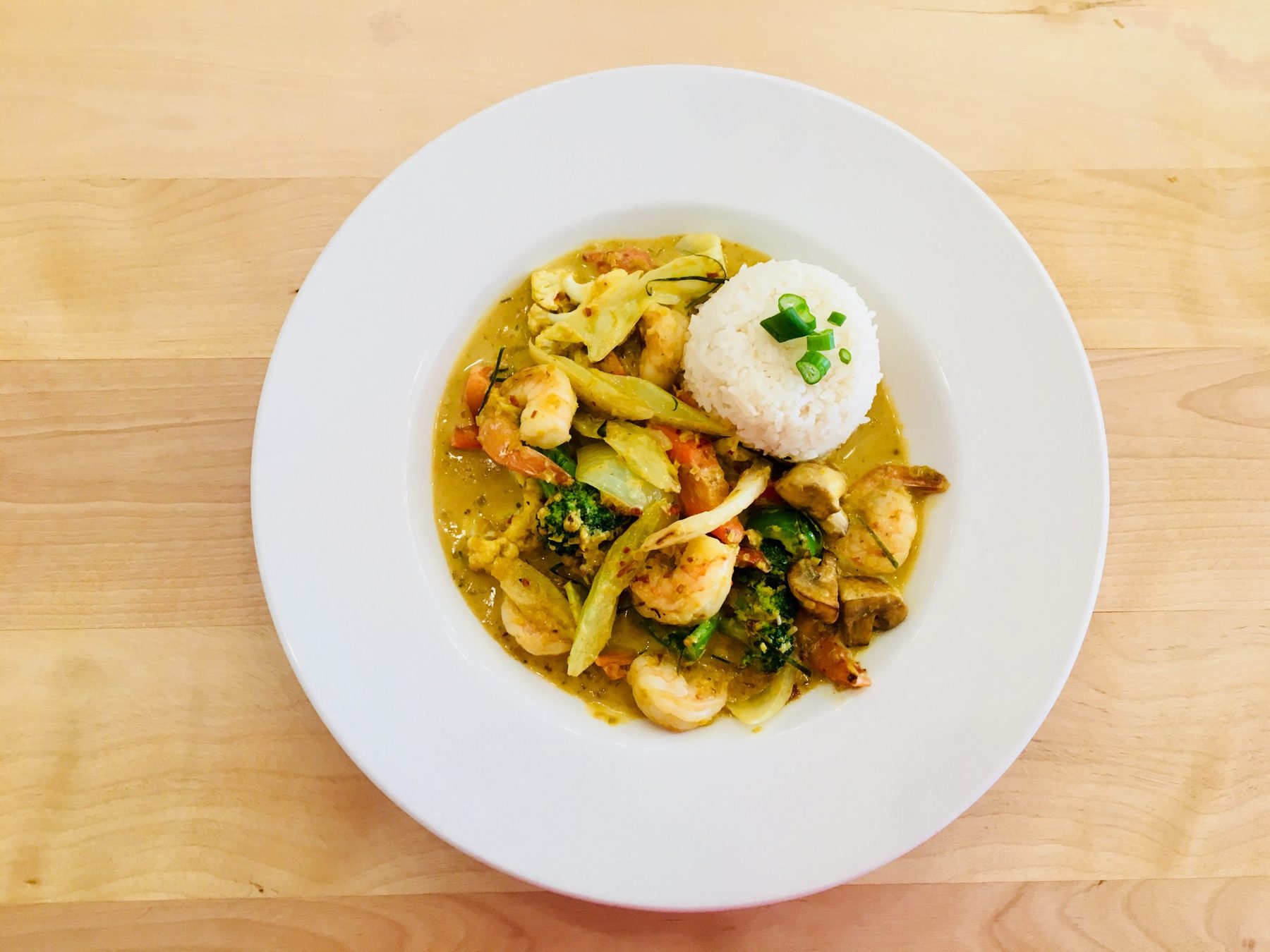Un sauté de crevettes au cari et légumes, servi avec riz
